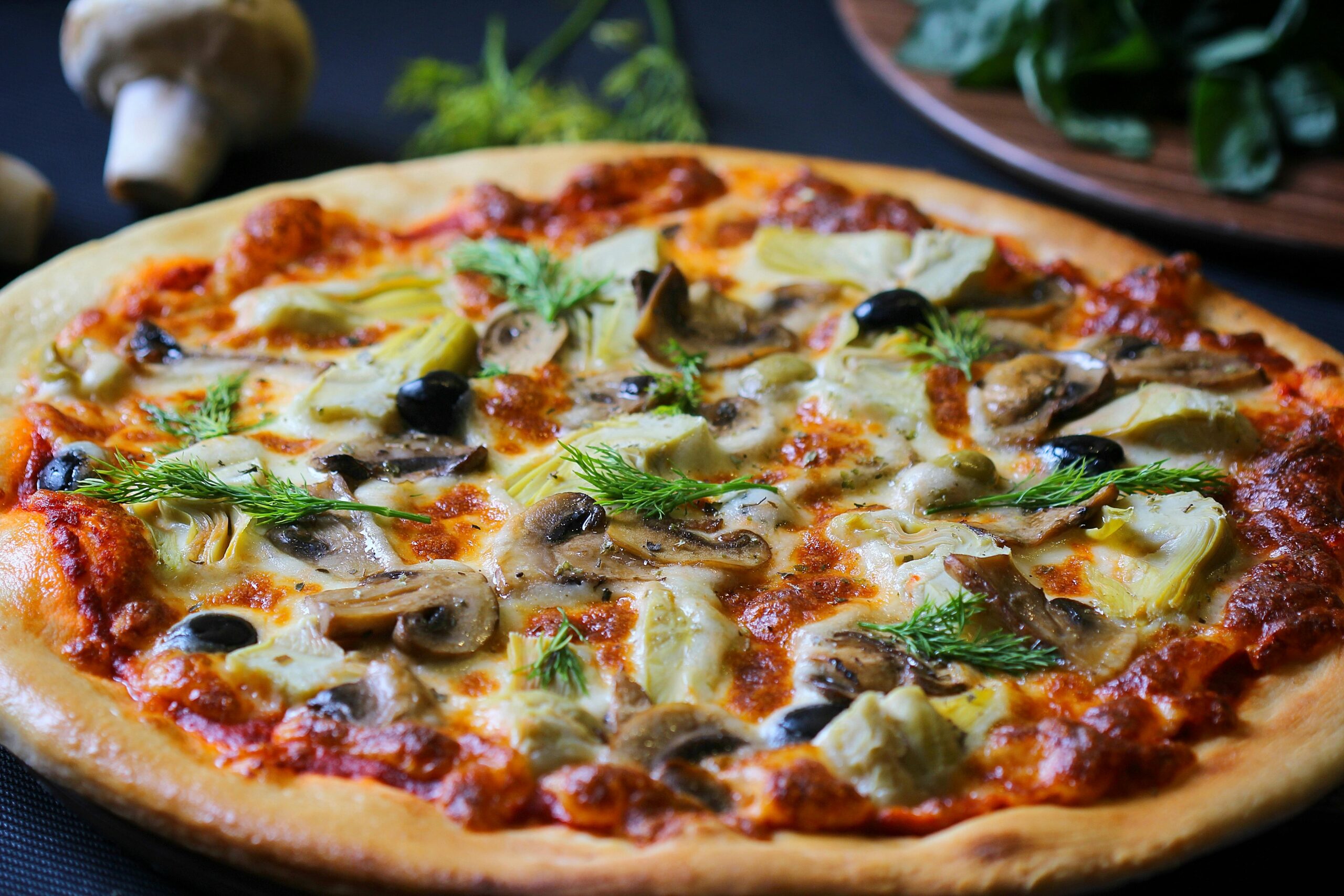 Home Close-up of a freshly baked vegetarian pizza with mushrooms, olives, and herbs perfect for food lovers.