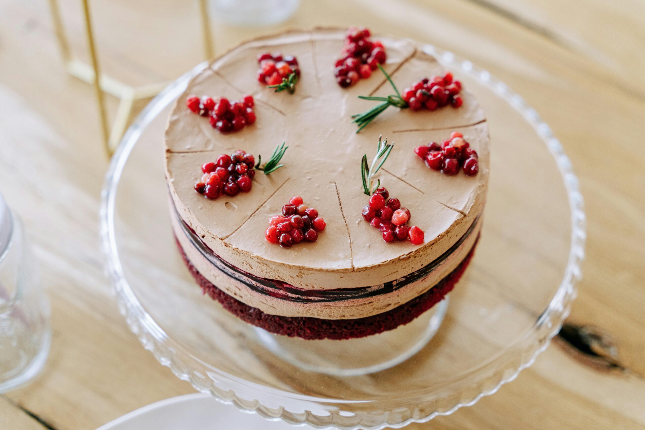 Home Chocolate dessert layered with cream, decorated with berries on a cake stand.